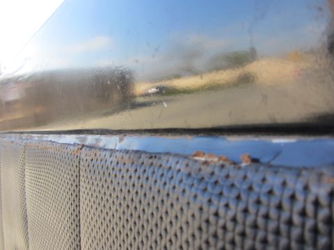 1964 Ford Ranchero - Close-up of a vehicle's door panel, showing the textured insert and a section of the painted exterior.