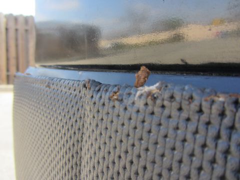 1964 Ford Ranchero - Detail of a textured door panel showing wear and rust on the upper edge.