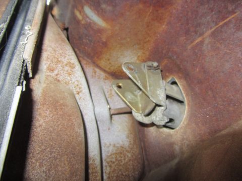 1964 Ford Ranchero - Close-up view of a corroded door panel latch mechanism and surrounding metal.