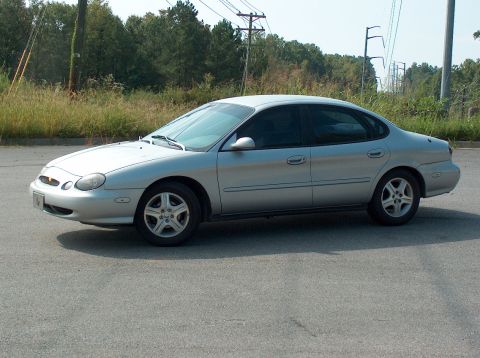 1998 Ford Taurus - Silver sedan with tinted windows and alloy wheels is seen from the side.