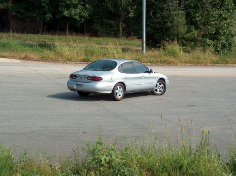 1998 Ford Taurus - This silver 1998 Ford Taurus is seen from its rear quarter angle on an asphalt lot.
