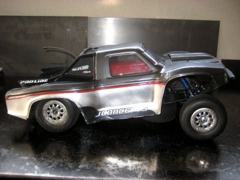 1996 Ford Bronco - This RC truck features a metallic silver body with red racing stripes and 'PROLINE' branding on the side.