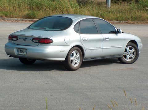 1998 Ford Taurus - Silver 1998 Ford Taurus sedan parked outdoors. Rear view shows the trunk and taillights.