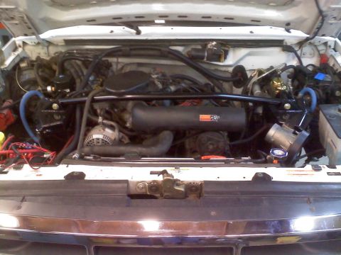 1996 Ford Bronco - The engine bay of a vehicle, a K&N air intake system and custom blue hoses.