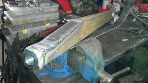 1987 Ford Ranger - A metal suspension component is secured in a vise, ready for work. Tools and storage containers are visible in the background.