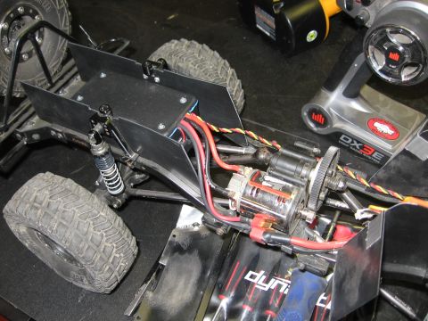 1993 Toyota 4Runner - Close-up view of a remote control car's chassis, showing the motor, wiring, and suspension components, alongside a DX3E transmitter.