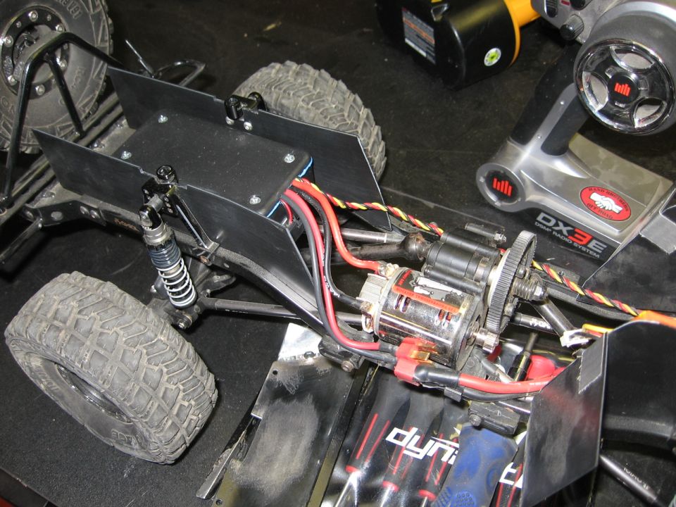 RC car chassis with motor, shocks, and remote control transmitter