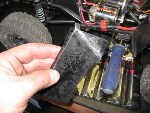 1993 Toyota 4Runner - Close-up of a hand holding a metal part near RC car electronics and a tire.