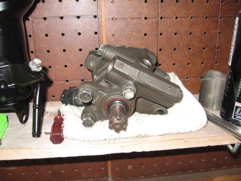 1993 Toyota 4Runner - A power steering pump is shown resting on a white cloth on a shelf, alongside other automotive parts.