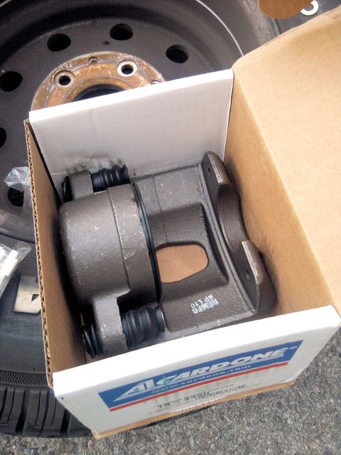 1994 Ford Bronco - A remanufactured twin-piston disc brake caliper sitting in its open A1 Cardone box on the pavement, dust boots and hardware bag included. A…