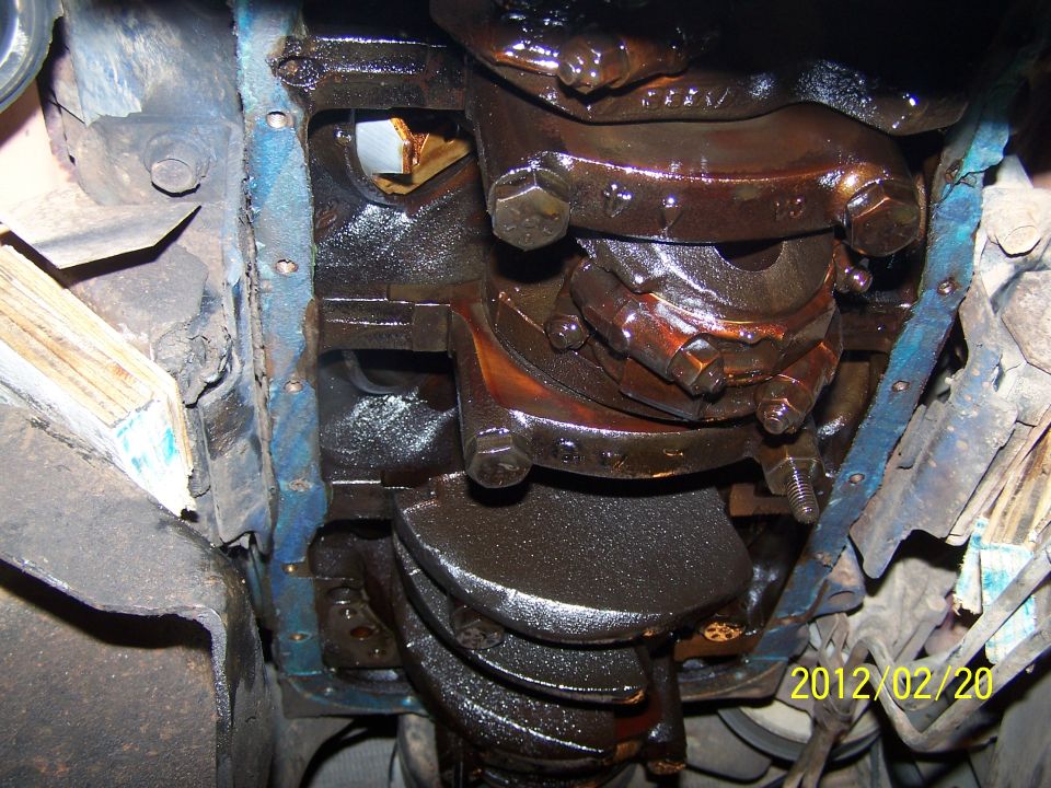 Engine crankshaft with oil pan removed, showing bearings and connecting rods. Date stamp 2012/02/20