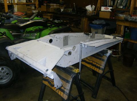 2000 Ford E350 - A vehicle chassis is prepped for work in a garage setting, with other items visible in the background.
