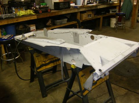 2000 Ford E350 - A disassembled vehicle chassis part is shown on sawhorses in a garage setting.