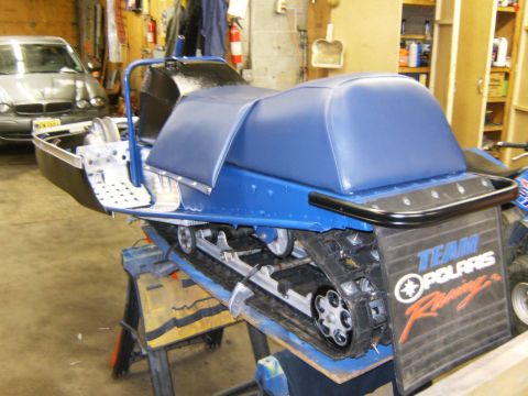 2000 Ford E350 - A blue snowmobile is on display in a garage, with a car visible in the background.