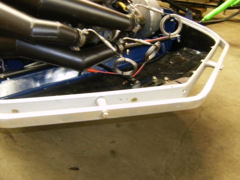 2000 Ford E350 - The engine and front section of a snowmobile are visible, with black exhaust pipes and a white frame.