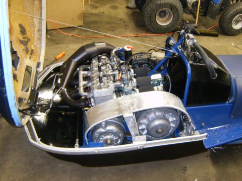 2000 Ford E350 - The engine and drivetrain of a blue snowmobile are visible with the hood open.