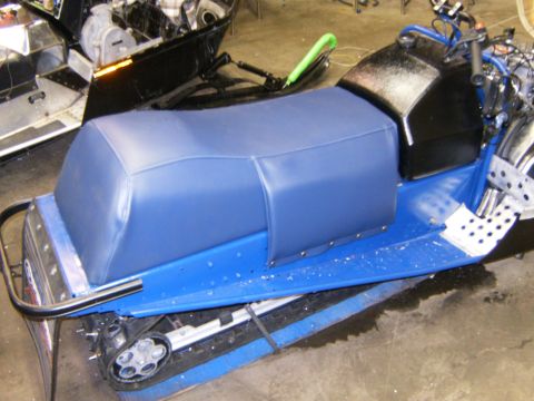 2000 Ford E350 - A blue snowmobile is shown from the side, with another snowmobile partially visible in the background.