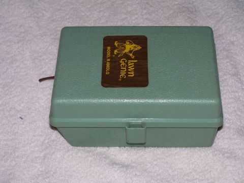 1973 Ford Bronco - A green plastic case with a "Lawn Genie" label is shown on a white textured surface.