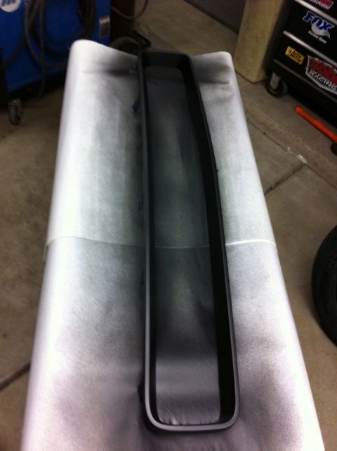 2010 Dodge Challenger - A black grille trim piece is shown on white paper, possibly being prepped for painting or installation.