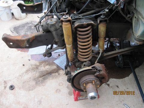 1979 Ford Bronco - Close-up of a vehicle's front suspension and steering system, with parts disassembled for maintenance.
