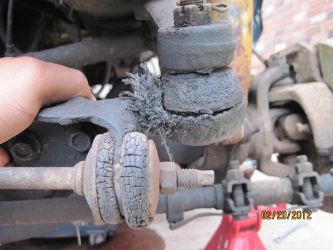 1979 Ford Bronco - The suspension components show significant wear and tear, with cracked rubber boots and frayed material.