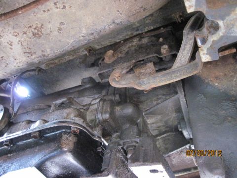 1979 Ford Bronco - Underside view of a vehicle's transmission and related components. A bright light illuminates the area from the left, and a date stamp read…