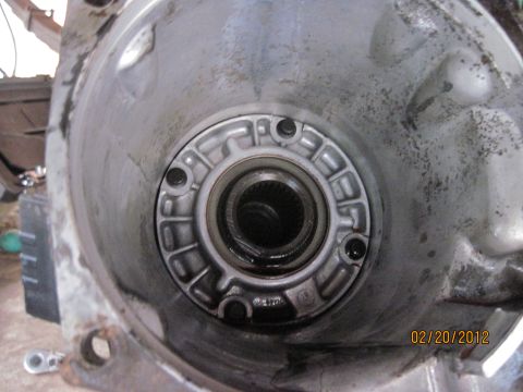 1979 Ford Bronco - Close-up view of the torque converter housing of a vehicle transmission. The housing is made of aluminum and shows signs of wear and dirt.…