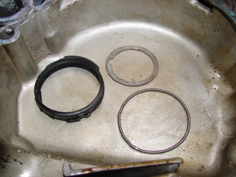 1973 Ford Ranchero - Close-up of an engine oil pan containing a damaged black seal and two metal rings.