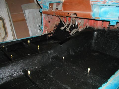 1960 Ford Ranchero - The interior floor of a classic vehicle, likely a 1960 Ford Ranchero, has been coated in a textured black protective material. The dashboar…