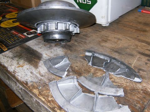 2000 Ford E350 - A damaged clutch assembly lies in pieces on a workbench, with a NOS sticker visible in the background.