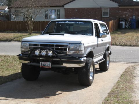 1994 Ford Bronco - This 1994 Ford Bronco is equipped with a bull bar and large off-road tires, parked on a concrete driveway.