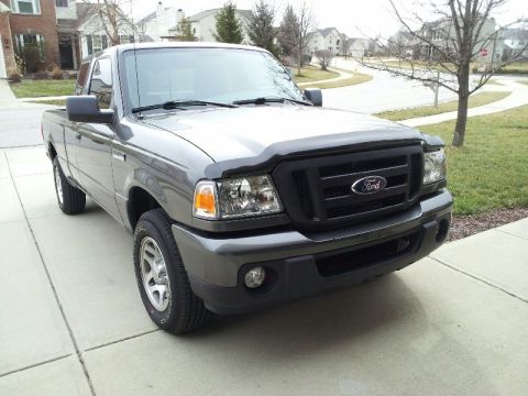 2011 Ford Ranger - Gray Ford Ranger pickup truck parked on a concrete driveway in front of houses.