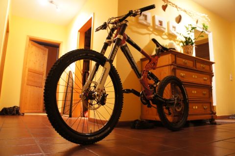 1973 Ford Ranchero - A mountain bike with a red frame and white front forks is parked in a hallway next to a wooden dresser.