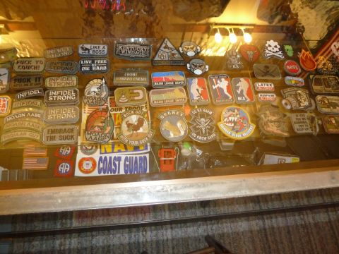 1992 Ford Mustang - A variety of embroidered patches and stickers are displayed on a surface, military themes and witty sayings.