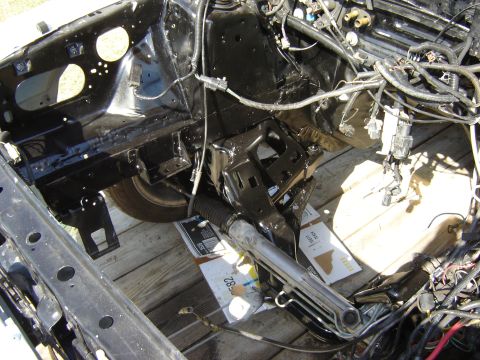 1987 Ford Mustang - Close-up of a car's chassis, showing engine bay components and wiring harness.