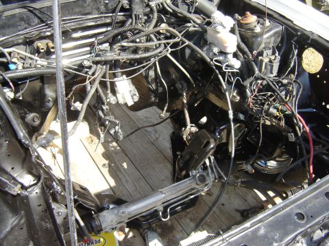 1987 Ford Mustang - The engine bay is exposed, revealing the car's internal components and wiring harness.