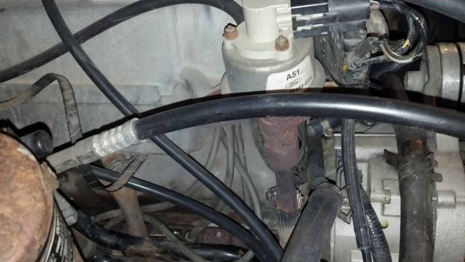 Engine bay with hoses, wires, and a part labeled A51 Ford