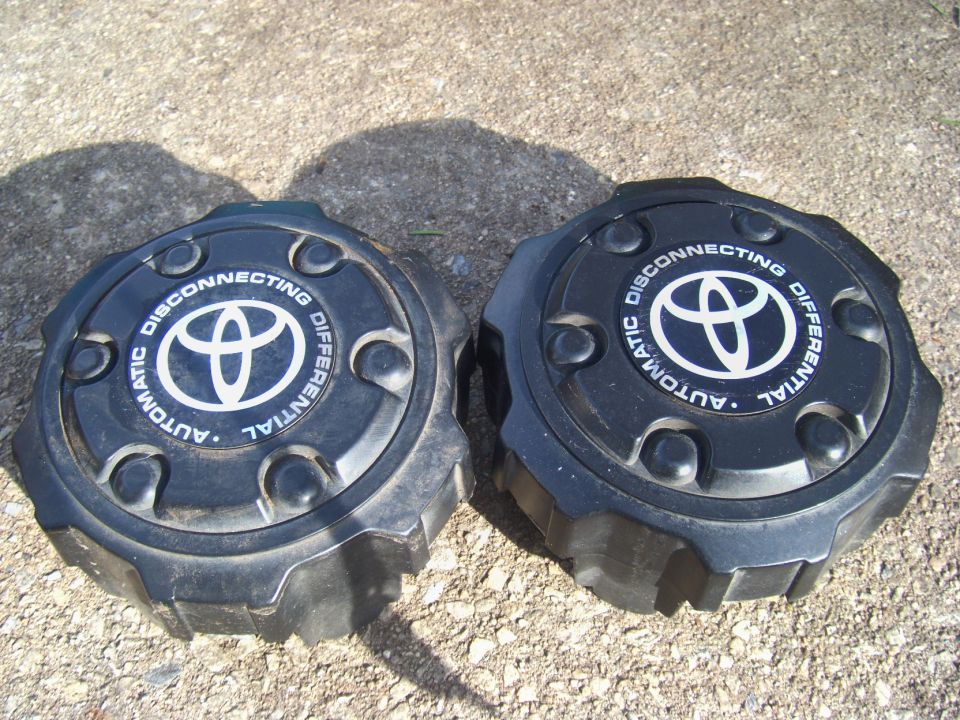 Two black Toyota automatic disconnecting differential caps