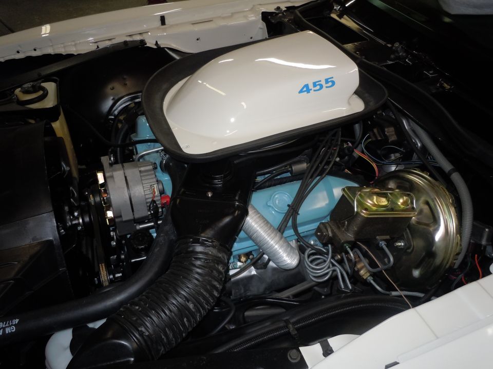 Engine bay of a 1973 Pontiac Trans Am with a white shaker hood scoop showing '455' in blue