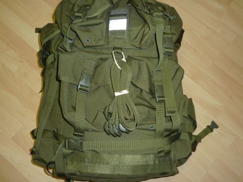 1992 Ford Mustang - A green backpack with numerous straps and buckles is shown against a wooden floor background.