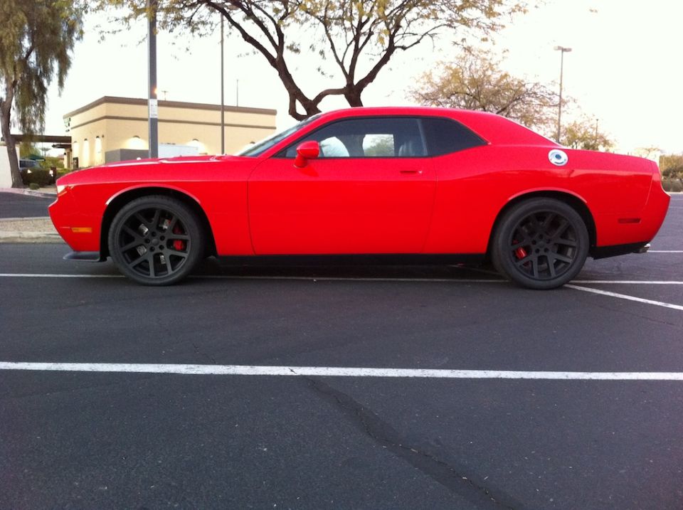 Red Dodge Challenger side profile on gunmetal wheels with red brake calipers