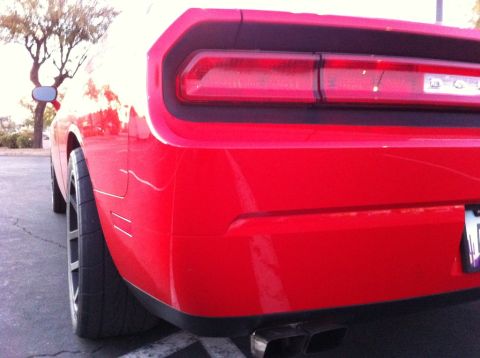 2010 Dodge Challenger - Rear view of a red Dodge Challenger, showing its distinctive taillight and wide tires.