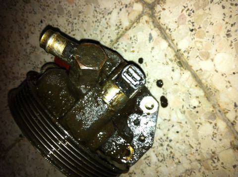 1998 Ford Crown Victoria - A greasy power steering pump is shown, likely removed for repair or replacement.