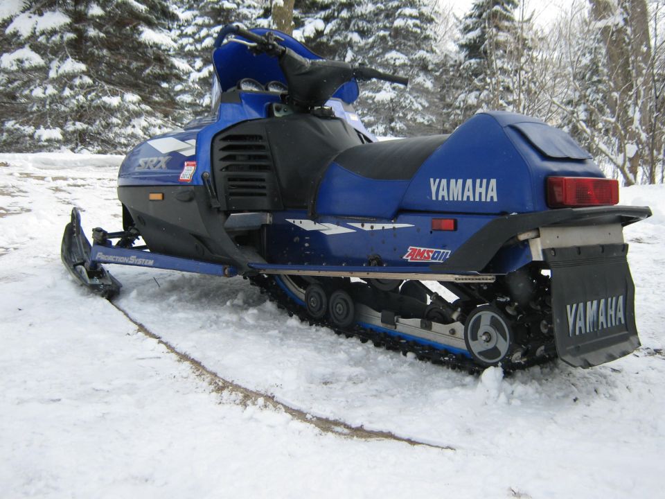 Blue Yamaha snowmobile with black seat and track, parked in snow