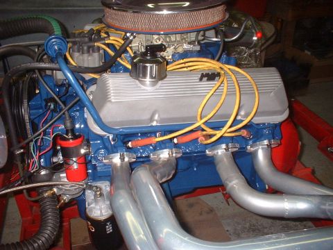 1969 Mercury Cyclone - Close-up view of a V8 engine silver valve covers, blue block, and yellow spark plug wires.