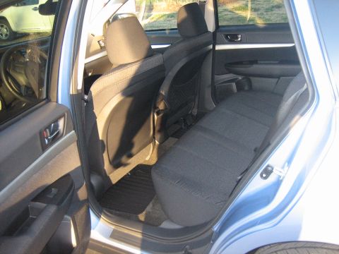 1996 Ford Thunderbird - Rear passenger area of a light blue sedan, showing cloth seats and door trim.