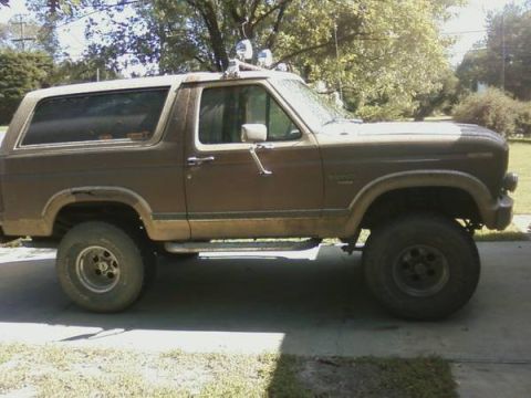 1991 Ford Ranger - Side view of a brown 1980 Ford Bronco, modified with off-road lights and wheels.