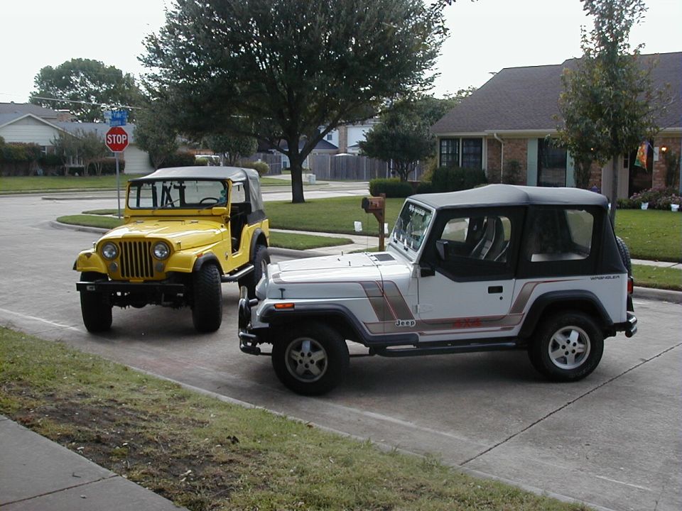 White Jeep Wrangler and yellow Jeep CJ parked on street