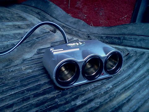 1989 Ford Bronco - Triple cigarette lighter adapter installed in a vehicle's interior.