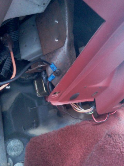 1989 Ford Bronco - Close-up view of interior wiring and a red metal panel with attached connectors.